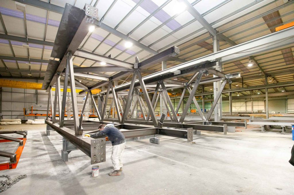 Steel Fabrication ( pre build) of Silverstone Circuit bridge priming of welds of massive bridge section  image by James Thompson Construction photographer.