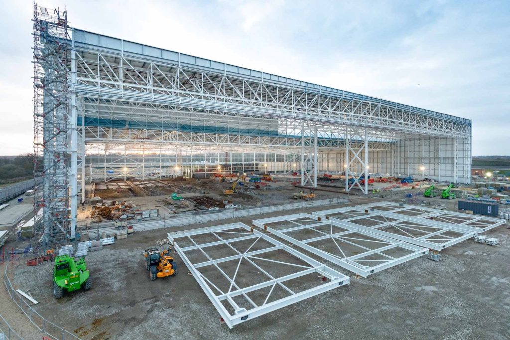 Gatwick Boeing Golden Care Hangar under construction showing massive steel framework with 20-tonne door frames positioned on ground for commercial aviation maintenance facility